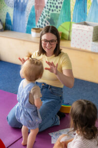 Kursleiterin zeigt Kleinkindern spielerisch Babyzeichen