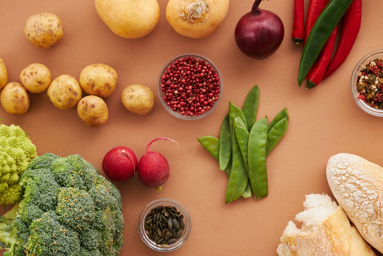 Top view of fresh ingredients including vegetables and bread, ideal for healthy cooking concepts.